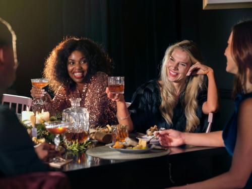 a group of people sitting around a table with food and drinks